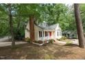Home exterior featuring a brick chimney, front porch, and well-maintained lawn at 616 Cross Timbers Dr, Durham, NC 27713