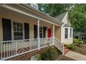 Inviting front porch with white railings and a vibrant red door, enhancing the home's curb appeal at 616 Cross Timbers Dr, Durham, NC 27713