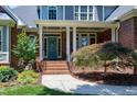 Inviting front porch with brick columns, detailed trim, and a decorative glass front door at 9048 Chelsea Dr, Raleigh, NC 27603