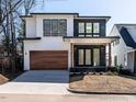 Eye-catching modern home with a stained wood garage door and a combination of white siding and dark brick at 1009 Parker St, Raleigh, NC 27607