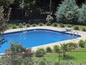 Inviting in-ground pool with diving board and meticulously landscaped backyard at 120 W Front St, Oxford, NC 27565