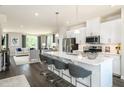 Modern kitchen with white cabinets, a large island with seating, stainless steel appliances, and dark wood floors at 1212 Tannin Dr, Durham, NC 27713