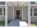 View of the main entrance featuring a classic black front door and white columns at 125 Davis St, Louisburg, NC 27549