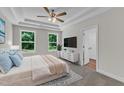 Serene main bedroom featuring tray ceilings, plush carpeting, and ample natural light through large windows at 125 Davis St, Louisburg, NC 27549