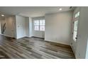 A large living room offers flexible layout options, adorned with vinyl flooring and bathed in natural light at 1559 Wendell Valley Blvd, Wendell, NC 27591