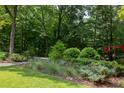 Professionally landscaped garden with lush plants, manicured shrubs, and charming stone pathway at 1908 S Lakeshore Dr, Chapel Hill, NC 27514