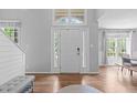 Bright foyer featuring hardwood floors, side lights, transom window, and high ceilings, creating an inviting entry at 208 Silk Hope Dr, Cary, NC 27519