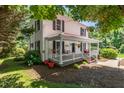 Charming two-story home featuring a welcoming front porch and beautifully landscaped surroundings at 210 Peachtree St, Roxboro, NC 27573
