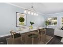 Bright dining room with seating for six, modern lighting, and a neutral color palette at 2106 White Pond Ct, Apex, NC 27523