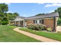 Inviting brick home featuring a lovely walkway and manicured landscaping at 2119 Northcrest Dr, Elon, NC 27244
