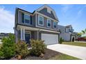 Charming two-story home featuring gray siding, stone accents, and a two-car garage with a concrete driveway at 22 Combine Trl, Benson, NC 27504