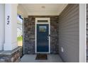 Stylish front entrance with a dark blue door, stone accents, and white columns showcasing modern design at 22 Combine Trl, Benson, NC 27504