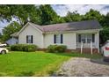 Charming home with gravel driveway and cozy front porch, enhanced by lush green lawn at 308 E Gilbreath St, Graham, NC 27253