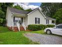 Cozy single-story home featuring a welcoming front porch and well-manicured lawn at 308 E Gilbreath St, Graham, NC 27253