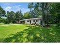 Lovely single-story home with fresh exterior paint, complemented by the large lot, landscaping, and mature trees at 313 13Th St, Butner, NC 27509