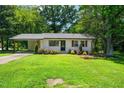 Inviting home featuring lush green lawn, established landscaping, and a welcoming entrance, perfect for families at 313 13Th St, Butner, NC 27509