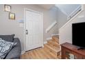 Inviting entryway featuring a white door, wood staircase, and neutral wall paint at 3622 Colchester St # 17, Durham, NC 27707