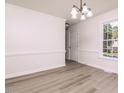Bright dining room with hardwood floors, crown molding, and a modern chandelier at 4416 Lancashire Dr, Raleigh, NC 27613