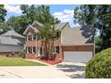 Traditional two-story brick home featuring an attached garage and a neatly landscaped front yard at 4733 Royal Troon Dr, Raleigh, NC 27604