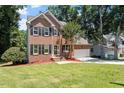 Charming two-story brick home with a well-manicured lawn and mature trees at 4733 Royal Troon Dr, Raleigh, NC 27604