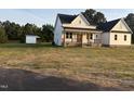 Lovely new construction home with a charming front porch and separate shed, set in a spacious, open yard at 50 Leah Ln, Louisburg, NC 27549