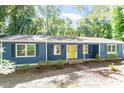 Charming blue home with a bright yellow front door and meticulously kept landscaping at 5124 Lazywood Ln, Durham, NC 27712