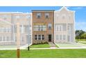 Brick townhome features a manicured lawn, neutral paint and charming black trimmed windows and doors at 529 Forestville Rd, Wake Forest, NC 27587