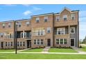 Brick townhomes feature a manicured lawn, neutral paint and charming black trimmed windows and doors at 529 Forestville Rd, Wake Forest, NC 27587