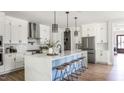 Bright kitchen with white cabinetry, an island with seating, and stainless steel appliances at 812 Ballaster Rd, Fuquay Varina, NC 27526