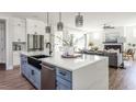 Modern kitchen island with a large sink, white countertops, and wood floors at 812 Ballaster Rd, Fuquay Varina, NC 27526
