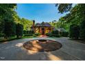 Stately brick home boasts manicured landscaping and circular driveway with fountain at 8200 Bromley Rd, Hillsborough, NC 27278