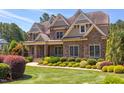 Beautiful stone home with manicured lawn and landscaping, showcasing curb appeal at 1009 Margarets Ln, Raleigh, NC 27614