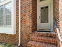 Close up of a front door, showcasing brickwork, steps and window details at 108 S Drawbridge Ln, Cary, NC 27513