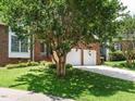 Charming two-story brick home with a well-manicured lawn, mature trees and a two-car garage at 108 S Drawbridge Ln, Cary, NC 27513