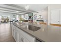 Close-up of kitchen island with modern faucet and stainless steel sink, leading to an open living area with stylish decor at 1250 Coach Station Aly # 201, Raleigh, NC 27601