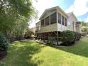 Beautiful backyard featuring a screened porch, wooden deck, lush lawn, mature trees, and a fire pit at 1316 Plunket Dr, Wake Forest, NC 27587