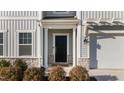 Close-up of a home's front door with stone accents, manicured shrubs, and a welcoming entrance at 158 Arlie Ln, Lillington, NC 27546