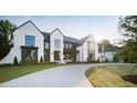 Stunning white brick home with dark trim, manicured lawn, and circular driveway at 1620 Hunting Ridge Rd, Raleigh, NC 27615