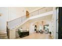 Elegant foyer with black railing staircase, herringbone floors, and an arched doorway at 1620 Hunting Ridge Rd, Raleigh, NC 27615