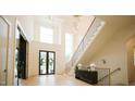 Grand foyer with a high ceiling, modern lighting, and staircase with black railing at 1620 Hunting Ridge Rd, Raleigh, NC 27615
