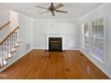 Bright living room featuring hardwood floors, a fireplace, and natural light at 2408 Tiltonshire Ln, Apex, NC 27539