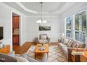 Bright living room featuring a decorative rug, plush seating, and natural light from the large windows at 2408 Tiltonshire Ln, Apex, NC 27539