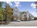 View of a multi-story condo building with garages and balconies under a blue sky at 2810 Bedford Green Dr # 5, Raleigh, NC 27604