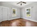 Bright living room featuring hardwood floors, a ceiling fan, and large windows at 2927 S Church St, Rocky Mount, NC 27803