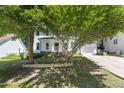 Beautiful two-story home with a white exterior, front porch, and mature trees in the yard at 3421 Tunas St, Raleigh, NC 27616