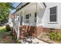 Charming front porch with brick stairs, white railings, and a view of the home's exterior at 3421 Tunas St, Raleigh, NC 27616