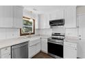 Bright kitchen with stainless steel appliances, white cabinetry and a farmhouse style sink at 3421 Tunas St, Raleigh, NC 27616