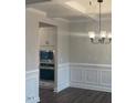 Formal dining room with wainscoting, coffered ceiling, and modern chandelier at 3509 Bailey Lake Dr, Fuquay Varina, NC 27526