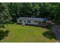 Charming single Gathering home features a covered porch and yard surrounded by lush forest at 40 Raccoon Xing, Henderson, NC 27537