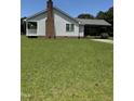 This home features a large yard and covered carport to the rear at 410 Carmil Dr, Selma, NC 27576